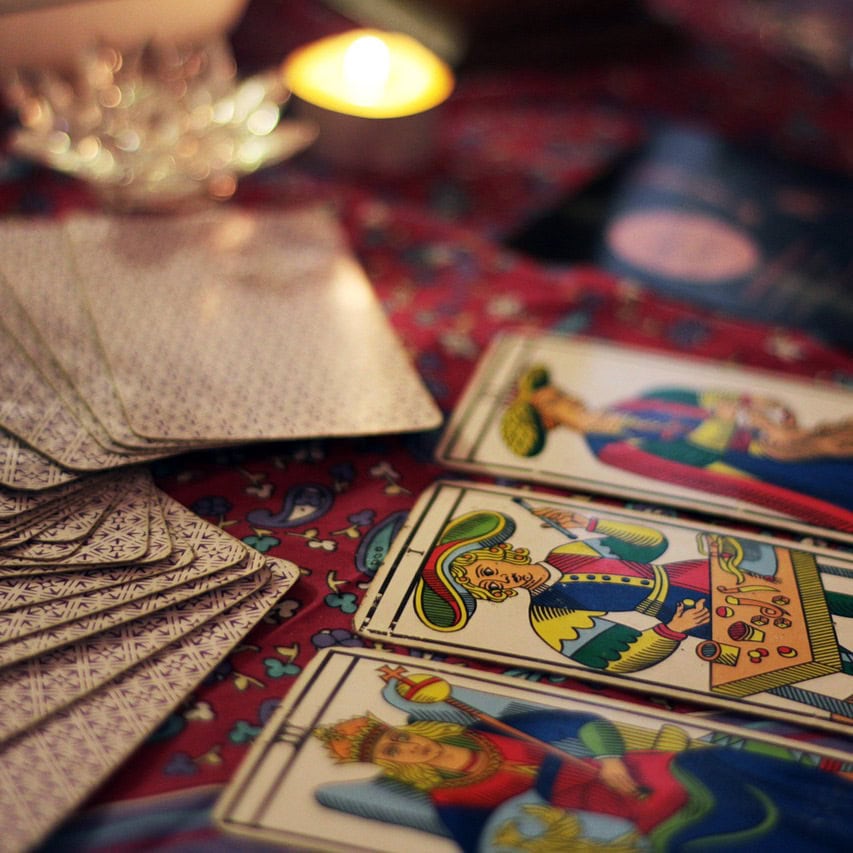Mystical divination scene with cards and celestial elements